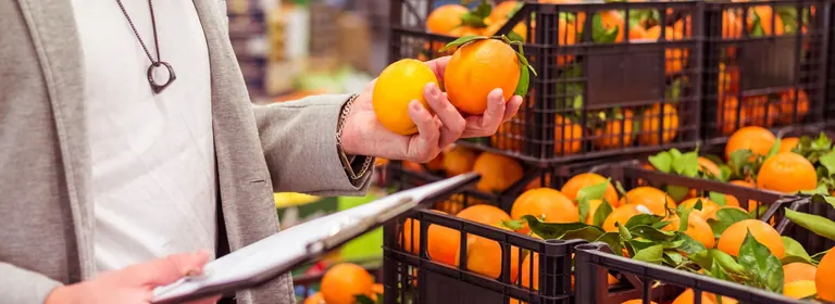 Une commerçante contrôle des fruits frais livrés